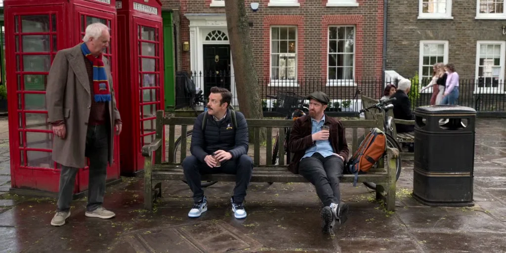 ted lasso and coach beard sitting on a bench richmond green